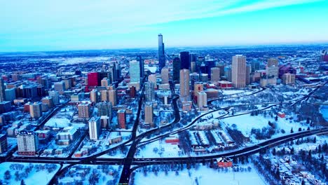 4k winter2-2 aerial forward flyover the rossdale massive empty parking lot across the edmonton prospects baseball club, and headed to the snow covered downtown core over bellamy hill rd nw windy city