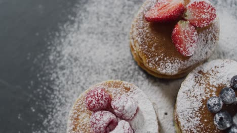 Video-of-pancakes-on-plate-seen-from-above-on-wooden-background