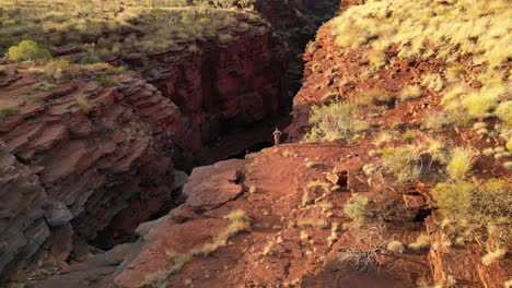 mujer admirando el panorama en el borde de joffre deep gorge durante una aventura de senderismo, desierto de australia occidental
