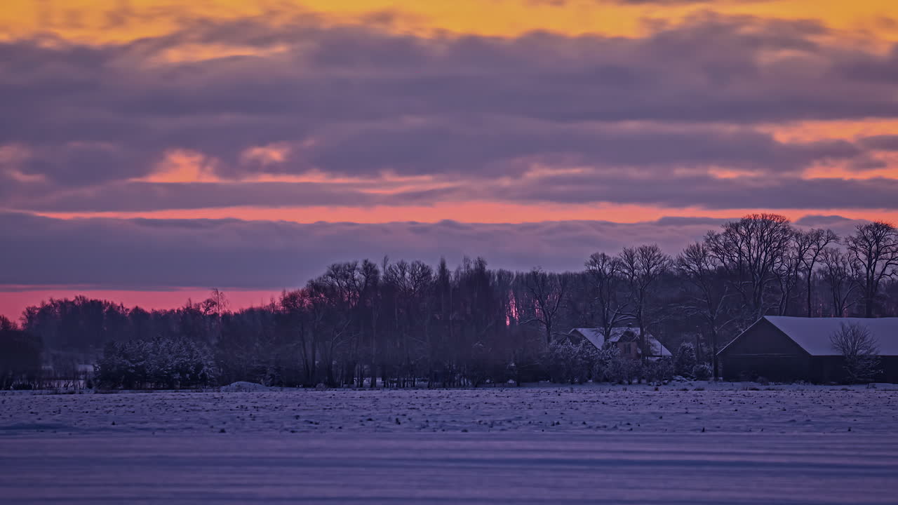 lapso de tiempo al atardecer del campo cubierto de nieve con casas y bosque