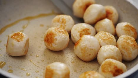 la persona del cultivo mueve las albóndigas a la sartén