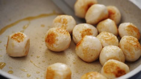 crop person move meatballs to frying pan