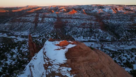 Drone-shot-flying-close-to-snow-coved-red-rock-mountains