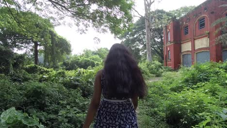 beautiful young girl walk towards scary abandoned house alone, slow motion, smooth dolly shot