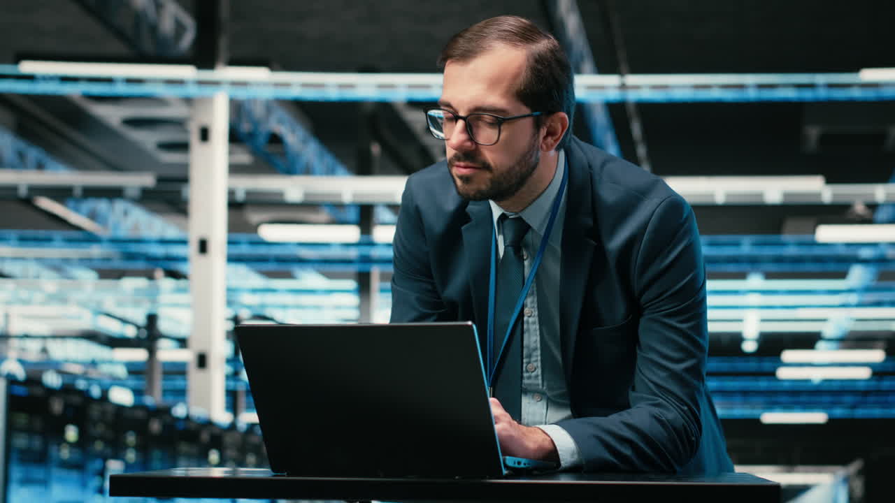 Professional Man Working on Laptop in Data Center