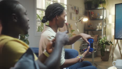 two young adults playing video games in a living room