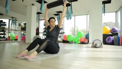 woman performing pilates exercise with foam roller
