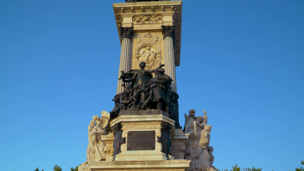 Un'inquadratura dal basso delle sculture ornate in pietra e bronzo sul Monumento ad Alfonso XII a Madrid. Adatto per documentari di viaggio e contenuti di storia europea