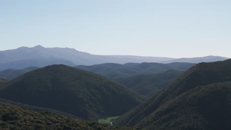 a breathtaking view of the klein karoo mountain range, western cape, south africa, bathed in bright sunlight. the clear blue skies accentuate the rugged terrain and expansive, majestic peaks