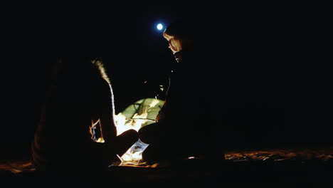 amigos asando malvaviscos junto a la fogata a altas horas de la noche