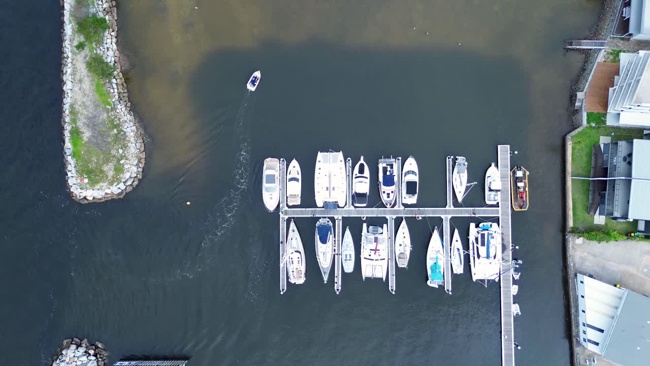 Drone aerial scenic view of boat in wharf dock waterfront harbour with boats yachts river inlet parking Batemans Bay South Coast Australia