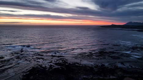 stunning seascape drone view during blue hour, golden strip above horizon