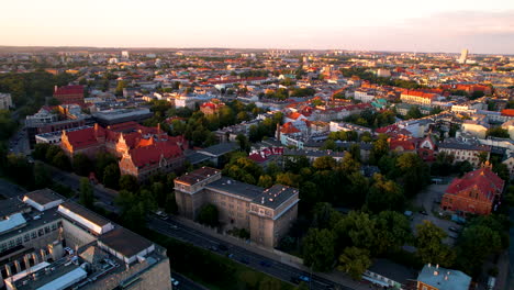 Toma-Panorámica-Con-Drones-De-La-Ciudad-Vieja-De-La-Iluminación-De-Cracovia-Durante-La-Puesta-De-Sol-Dorada-Y-El-Cielo-Rosa