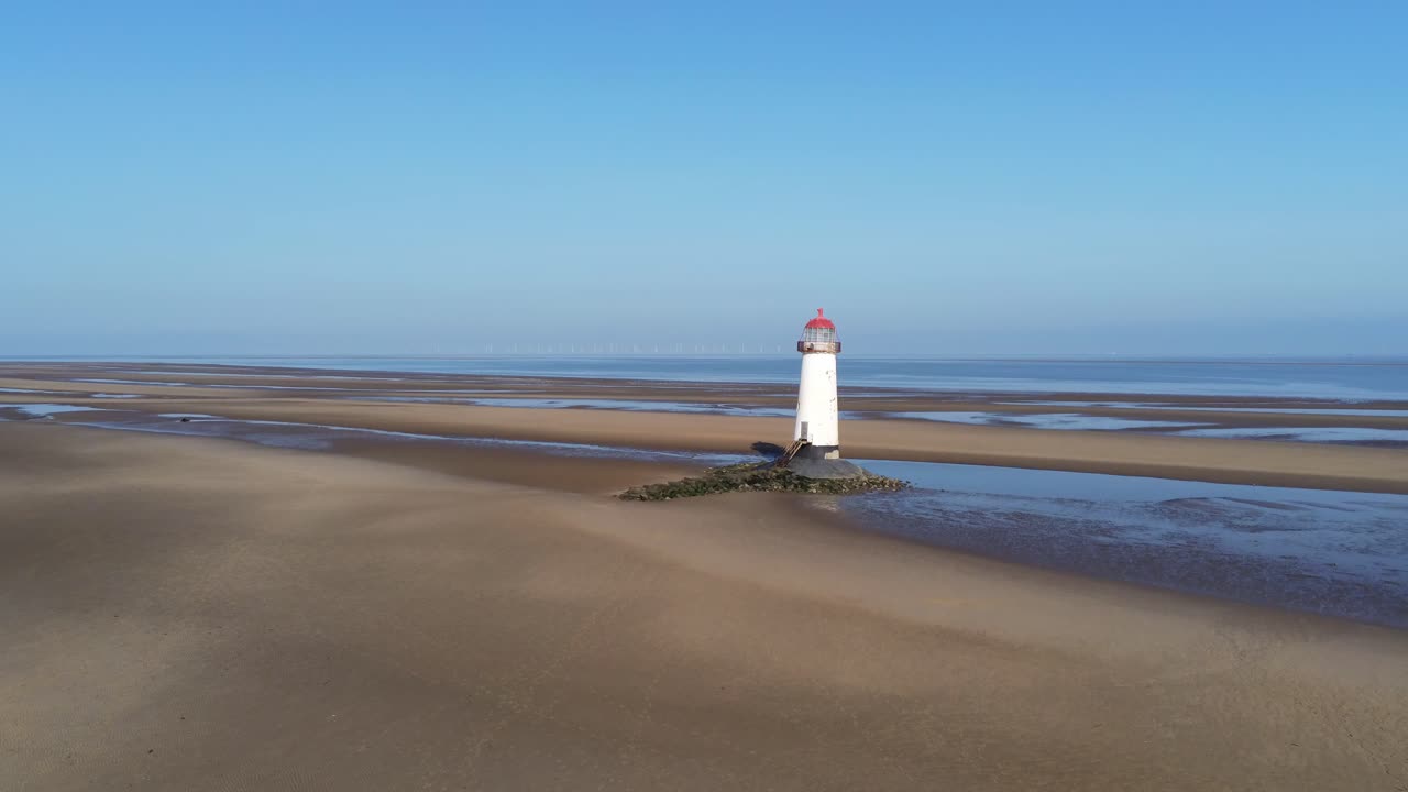 talacre cúpula roja faro arena dorada marea baja playa amanecer vista aérea hacia atrás