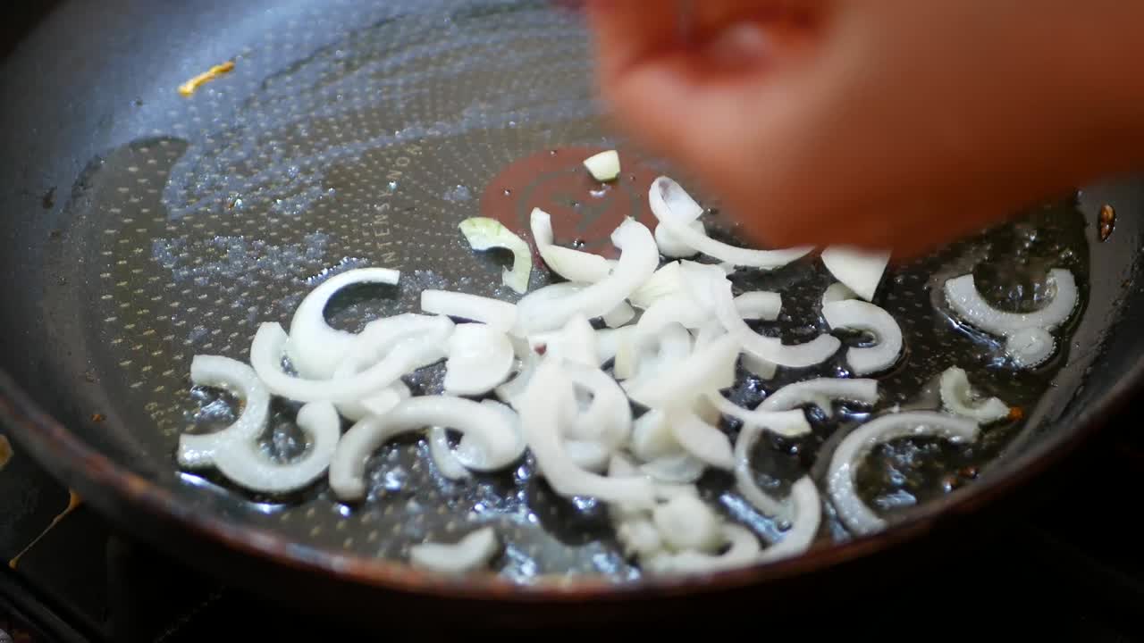 Onion fried in a pan close-up. Steam in a pan while frying vegetables