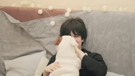 a girl at home with her dog , happily cuddling each other, the pet licks her face