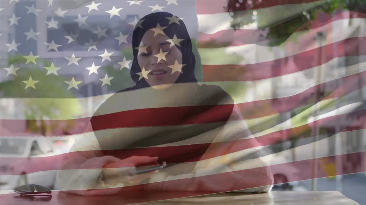 animación de la bandera estadounidense ondeando sobre una mujer de raza mixta en hijab hablando en su teléfono inteligente