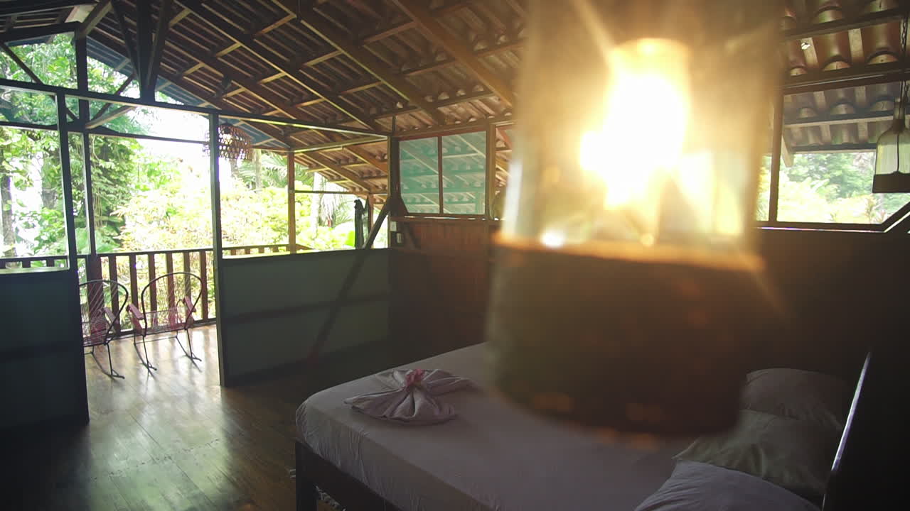Looking out from a beautifully decorated private beach resort room with a white linen bed and natural wood paneling.