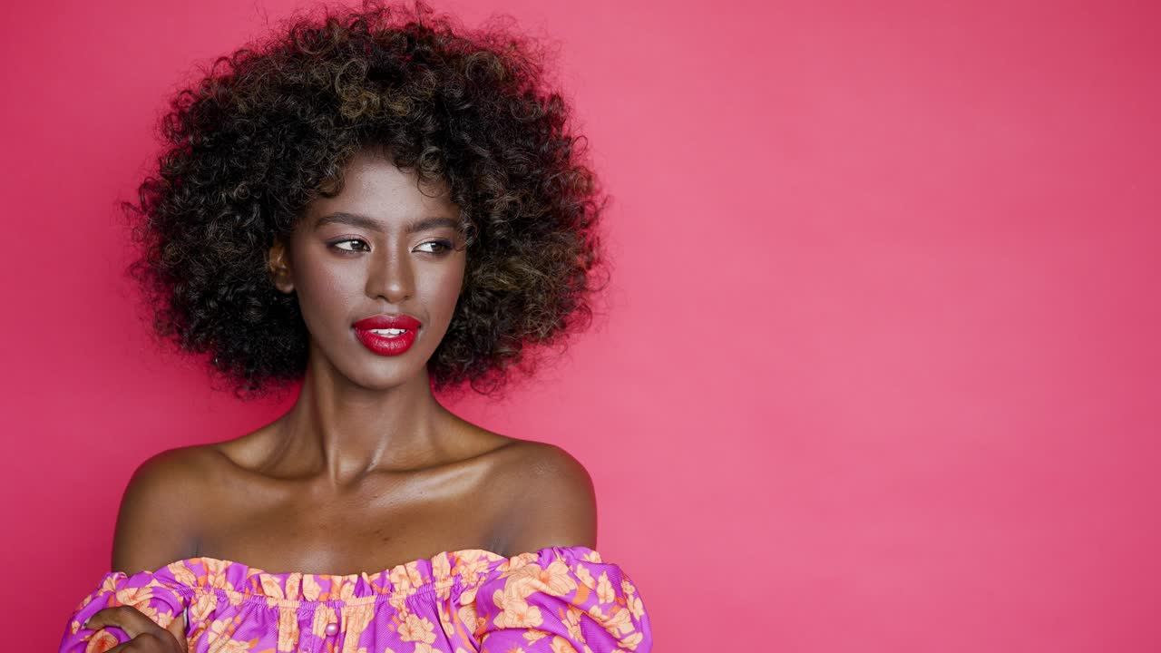 elegante mujer afroamericana en un vestido floral fuera de los hombros