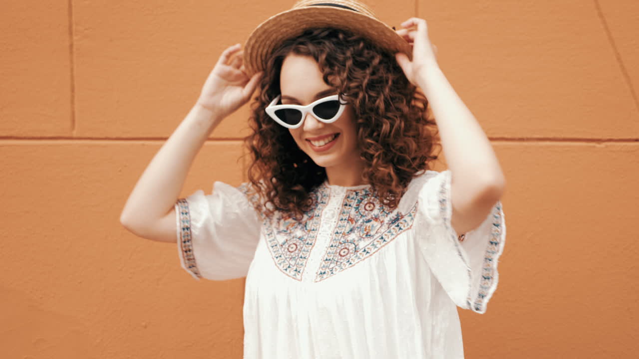 mujer elegante con cabello rizado y sombrero de paja
