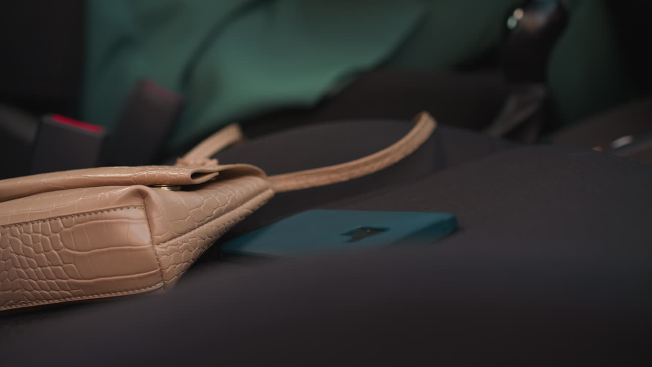 mujer con uñas rojas lanza un teléfono inteligente en el asiento del pasajero