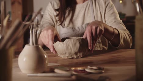 young woman potter forming a bowl out of soft clay with her hands