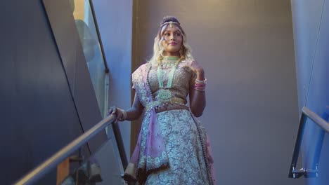 descending a staircase is a young woman of east indian heritage, gracefully dressed in traditional indian attire