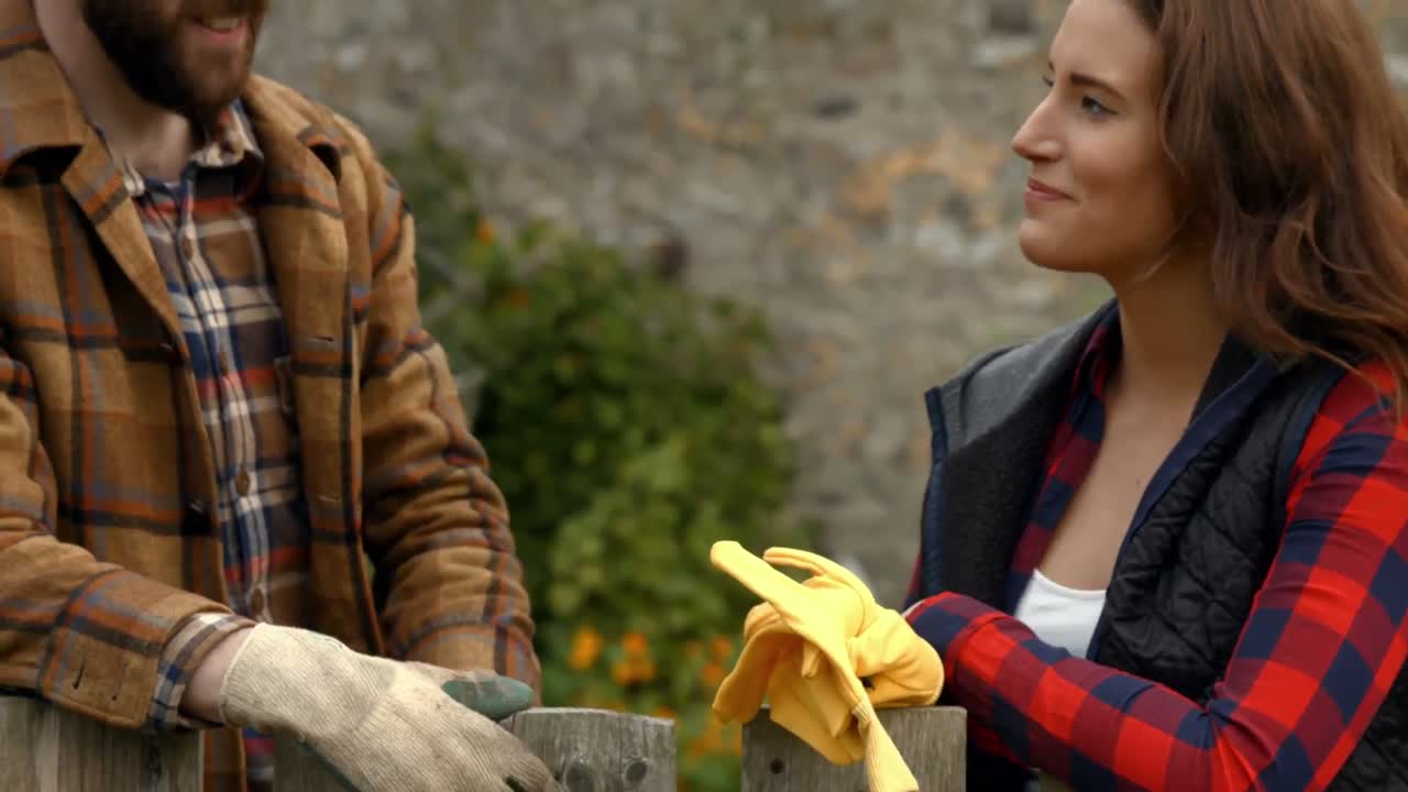 una pareja joven hablando en el jardín.