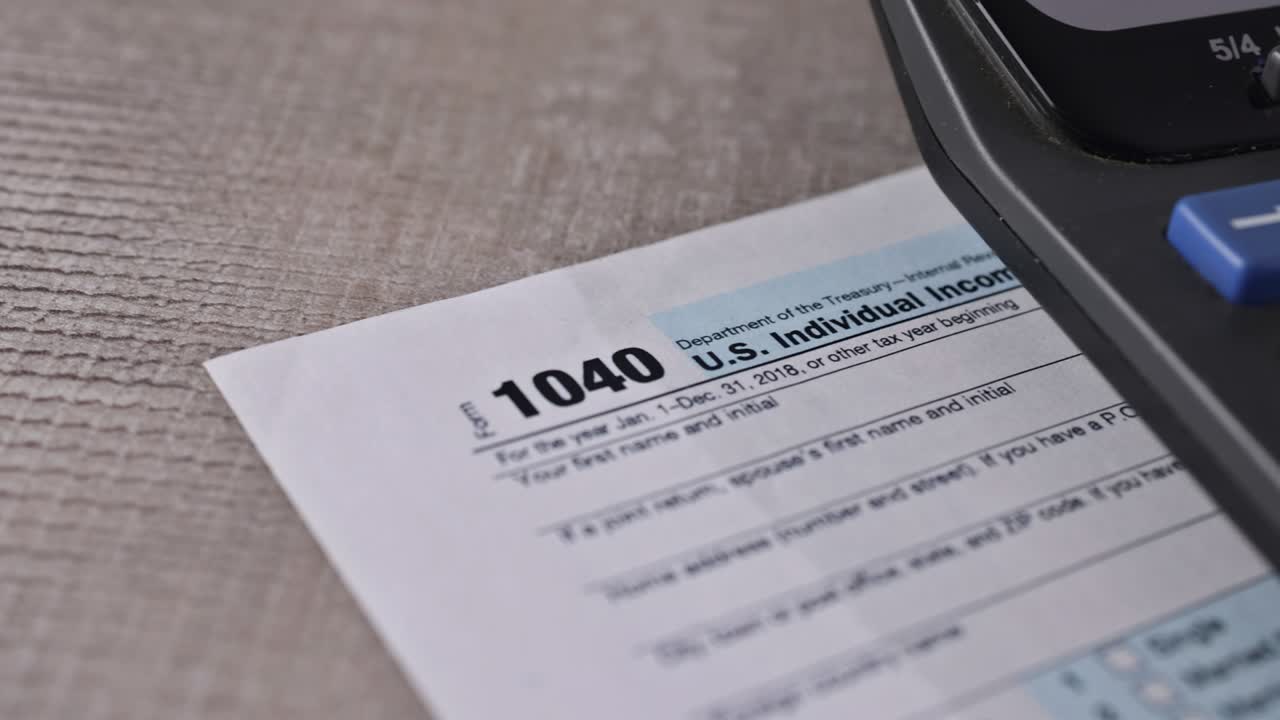 formulario de impuestos 1040 con cheque de reembolso y moneda billetes de dólar estadounidense de primer plano