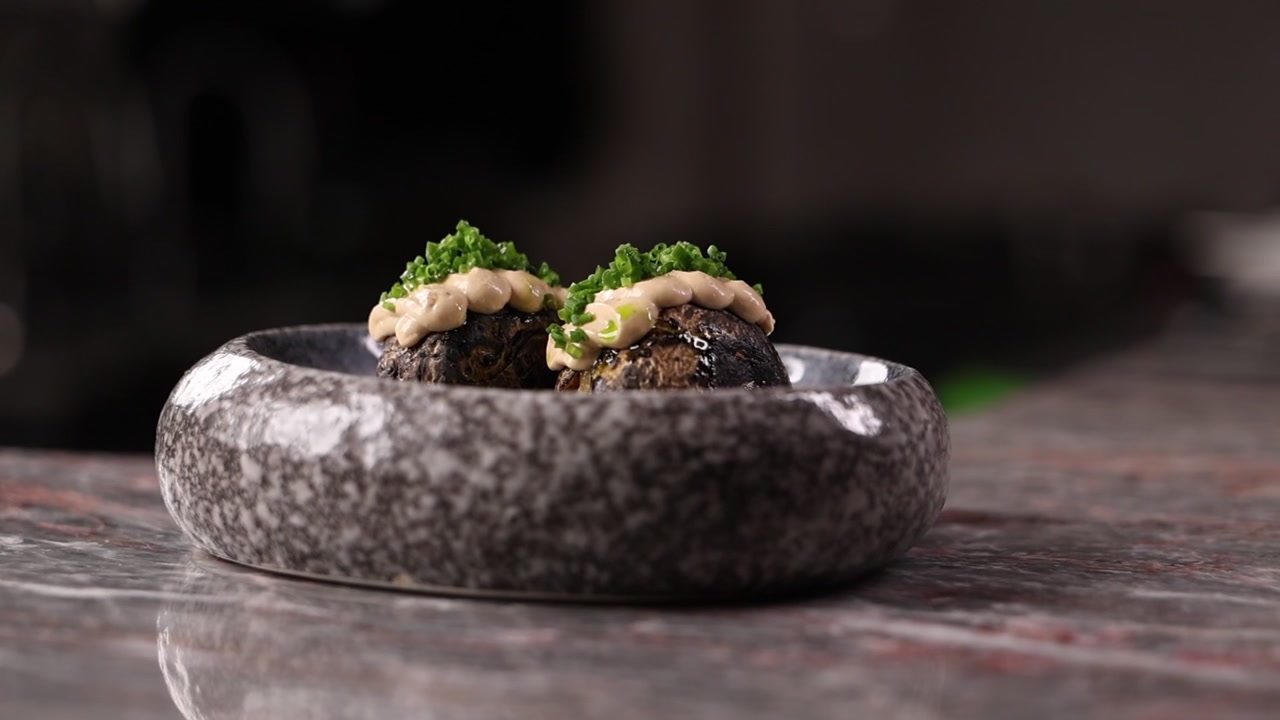 Polpette Gourmet Guarnite con Salsa Cremosa ed Erba Cipollina in Ciotola di Pietra