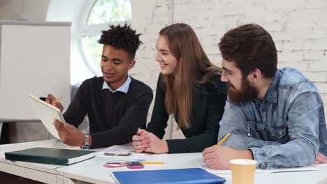 multi ethnic group of people working together. young african guy explaining something to his colleagues. happy diverse group of