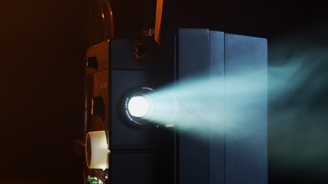 proyector de películas super-8 que muestra películas caseras en una habitación llena de humo