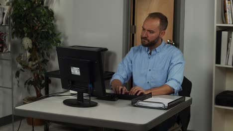 happy male office worker, types on keyboard