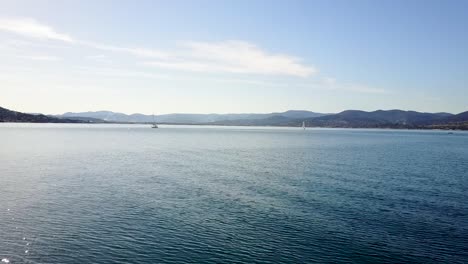 serene seascape: sailboats on calm waters with mountain views