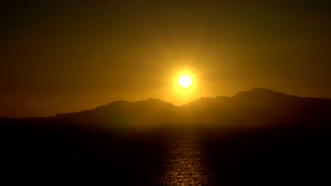 el sol naciente sobre el mar y las montañas del desierto