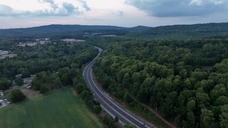 an aerial view of traffic on a highway in the late evening light with the last color of the sunset leaving the sky