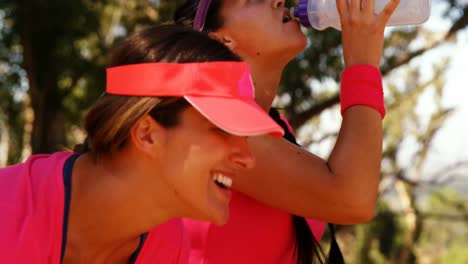 women drinking water after workout in the boot camp