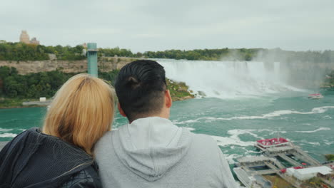 A-Young-Multi-Ethnic-Couple-Of-Tourists-Admire-The-View-Of-The-Famous-Niagara-Falls-From-The-Canadia