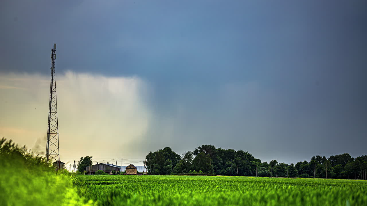 torre de telecomunicaciones en el campo sobre campos verdes con cielo nublado