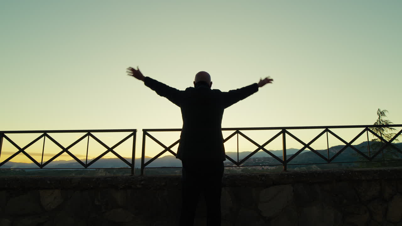silueta de un hombre saludando feliz con la mano desde la vista panorámica de la ciudad