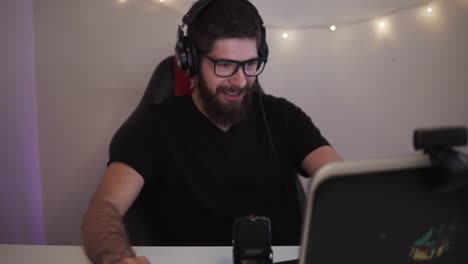 um homem adulto está jogando em um laptop enquanto faz uma transmissão para o youtube ou contração ao vivo