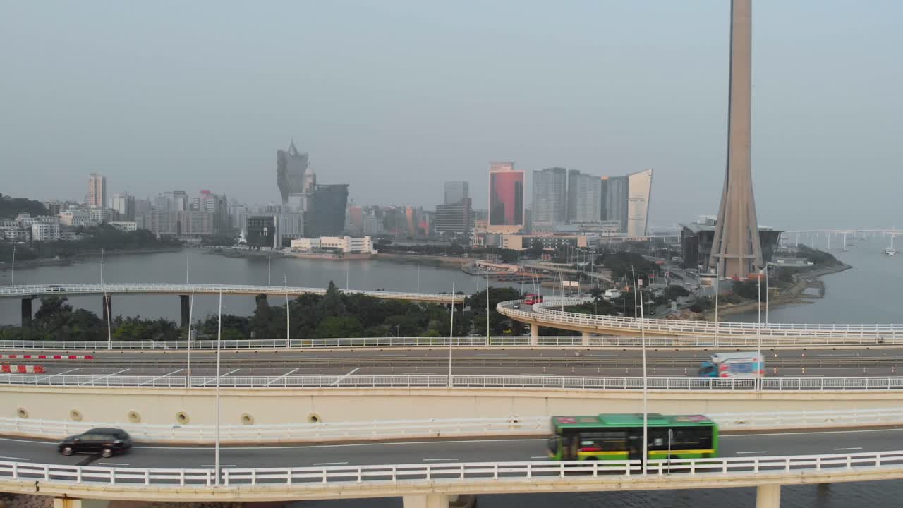 Aerial shot rising above Sai Van Bridge and revealing Macau skyline on a hazy day