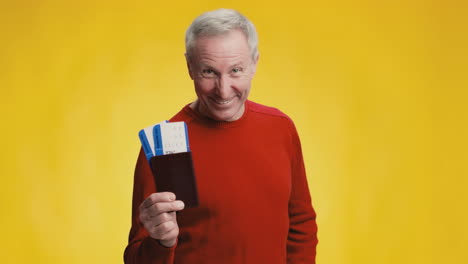 senior man holding passport and tickets