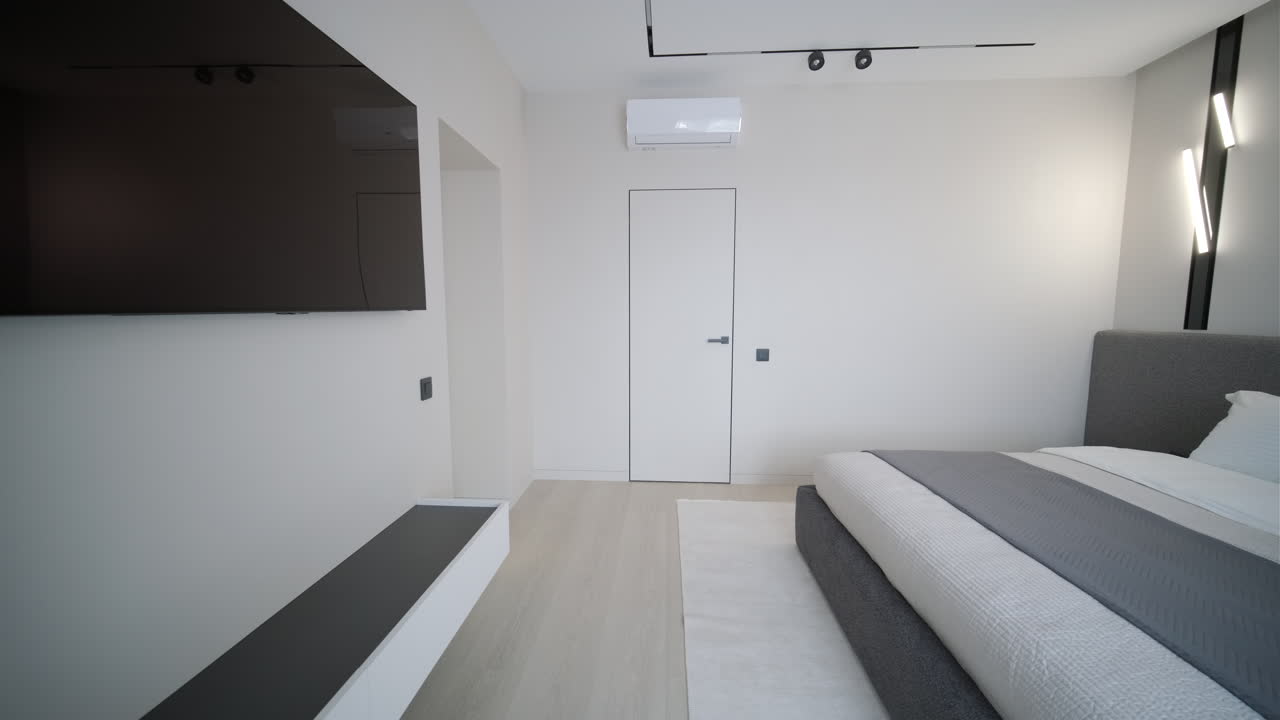 Interno camera da letto moderno e minimalista con letto grande e TV
