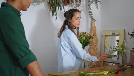 inspirado florista hacer composición flores en la tienda. joven tienda de rosas regalo.