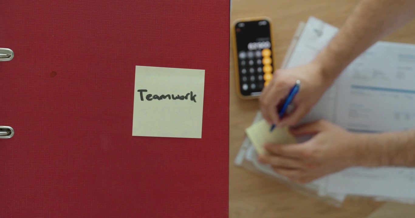 Concetto di lavoro di squadra con colleghi che collaborano su documenti aziendali sullo sfondo. Ideale per cooperazione, lavoro di squadra, produttività in ufficio e concetti aziendali