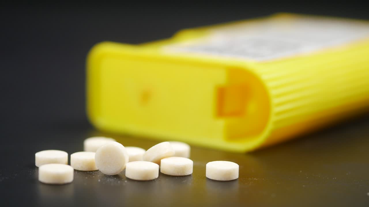 둥근 색 사탕을 가진 노란색 용기