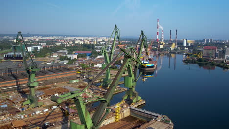 vista aérea de viejas grúas de contenedores oxidadas en el puerto de gdansk durante el día soleado