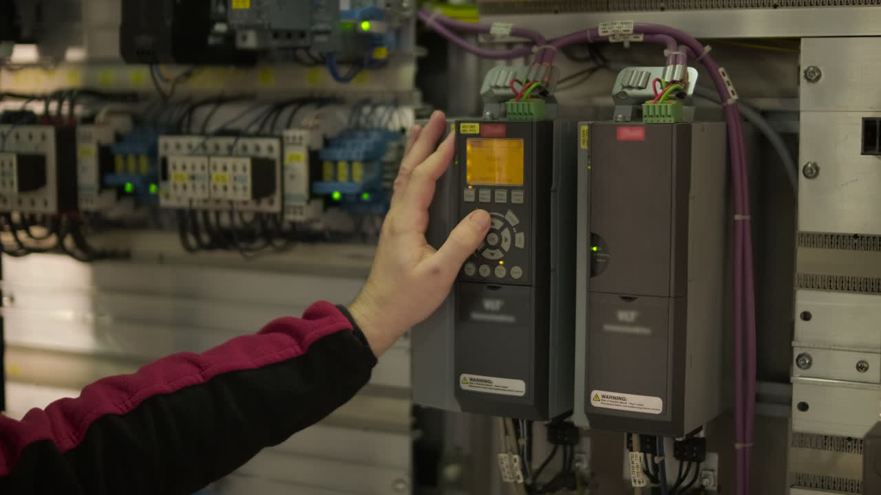 Engineer's Hand Operating Industrial Control Panel Settings