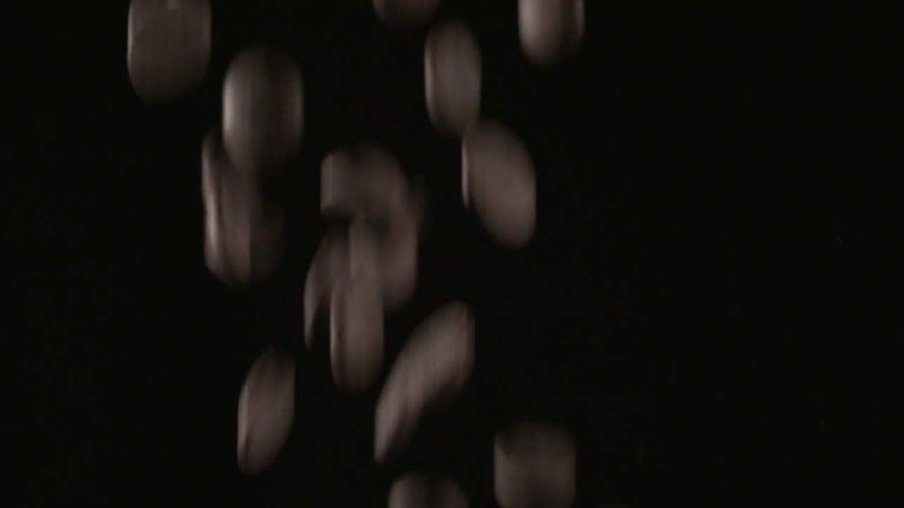 muchas chispas de chocolate cayendo, disparadas sobre un fondo negro